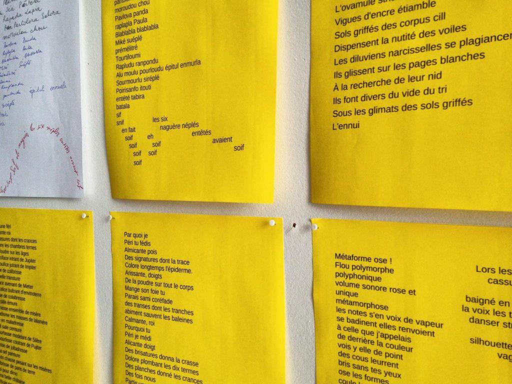 Textes sur feuilles jaunes accrochées au mur